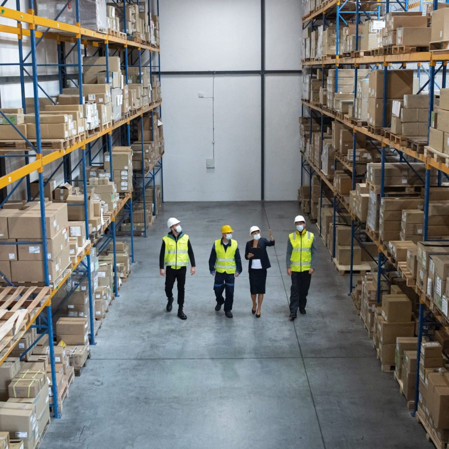 Top view of group of workers with manager working indoors in warehouse, coronavirus concept.
